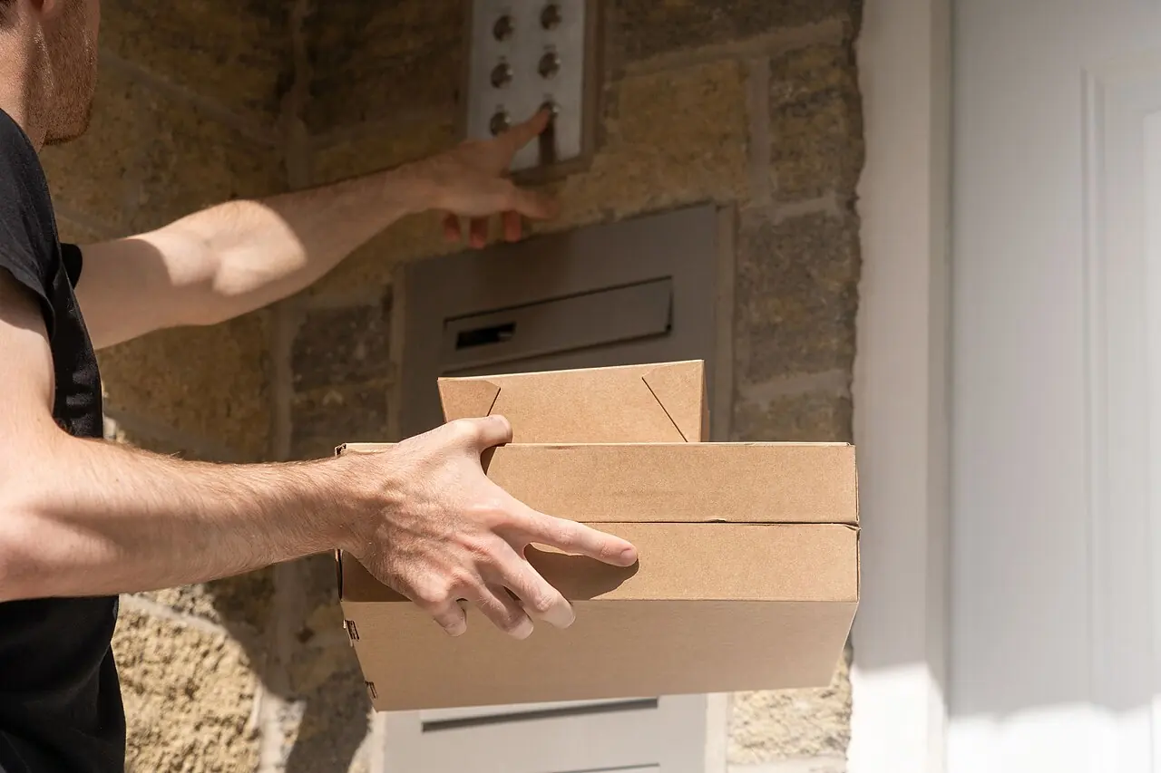 Delivery driver at a front door holding packages