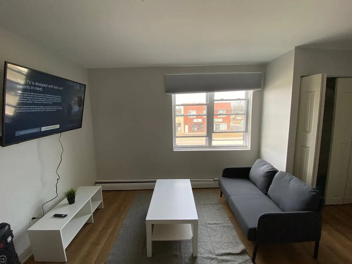 Living room with sofa, wall-mounted TV and coffee table